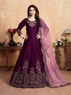 Here Is A Very Beautiful Heavy Designer Floor Length Suit In Wine Color Paired With Pink Colored Dupatta. Its Top Is Fabricated On Art Silk Paired With Santoon Bottom And Net Fabricated Dupatta. It Has Heavy Embroidered Neck Line And Panel, Also With An Attractive Cut Work Dupatta.Buy Now.