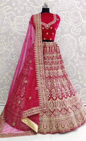Get Ready For Your D-Day With This Heavy Designer Lehenga Choli In Rani Pink Color. This Heavy Embroidered Lehenga Choli Is Fabricated On Velvet Paired With Net Fabricated Dupatta. It Is Beautified With Heavy Jari Embroidery And Stone Work. Buy This Bridal Lehenga Now