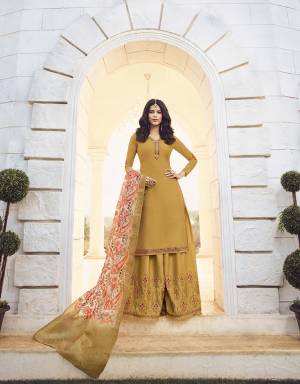 Celebrate This Festive Season Wearing This Heavy Designer Sharara Suit In Musturd Yellow Color Paired With Cream Colored Dupatta. Its Top And Bottom Are Muslin Georgette Based Paired With Jacquard Silk Fabricated Floral Printed Dupatta. 