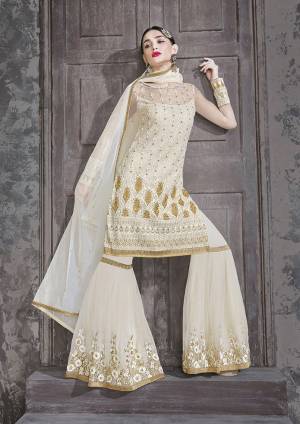 Flaunt Your Rich and Elegant Taste Wearing This Designer Sharara Suit In Elegant Off-White Color. This Pretty Semi-Stitched Suit In Fabricated on Net Beautified Subtle Embroidery Giving Heavy Look. 
