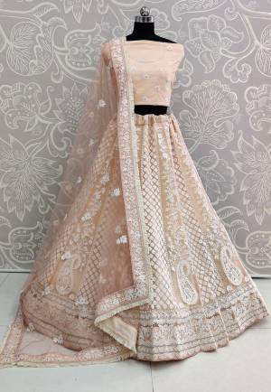 Get Ready For The Upcoming Wedding Season Wearing This Heavy Designer Lehenga Choli In All Over Light Peach Color. It Blouse, Lehenga And Dupatta Are Fabricated On Net Beautified With White Colored Thread Embroidery. Buy Now.