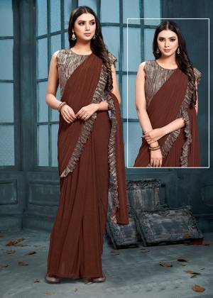 Here Is An Elegant Designer Saree In Brown Color Paired With Brown Colored Blouse. This Saree And Blouse Are Fabricated On Fancy Fabric. This Designer Piece Has A Saree Look In Gown Pattern. It Is Easy To Wear And Carry All Day Long. 
