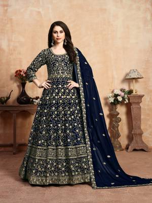 Get Ready For The Upcoming Wedding Season With This Heavy Designer Floor Length Suit In Navy Blue Color. Its Heavy Embroidered Top Is Fabricated On Georgette Paired With Santoon Bottom And Georgette Fabricated Dupatta Which Has Pretty Elegant Embroidered Buttis And Lace Border. 