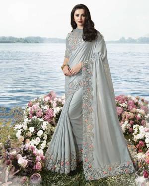 Rich And Elegant Looking Designer Saree Is Here In Light Grey Color. This Saree Is Fabricated On Tissue Silk Paired With Art Silk And Net Fabricated Blouse. It Has Elegant Tone To Tone Embroidery With Attractive Peach Colored 3D Flowers. 