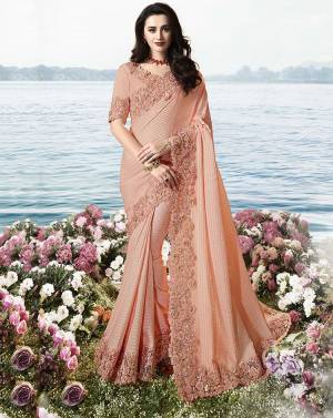 A Must Have Shade In Every Womens Wardrobe Is Here With This Designer Peach Color Saree Paired With Peach Colored Blouse. This Saree Is Fabricated On Fancy Soft Silk Paired With Art Silk And Net Fabricated Blouse. 