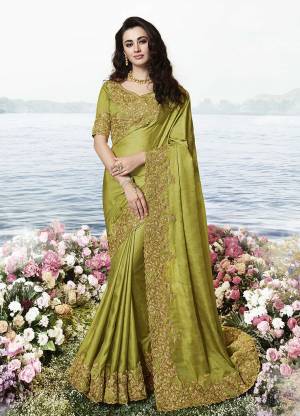 You Will Definitely Earn Lots Of Compliments Wearing This Heavy Designer Saree In Olive Green Color. This Pretty Saree Is Soft Silk Based Paired With Art Silk And Net Fabricated Blouse. Buy Now.