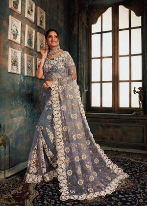 Look Pretty Wearing This Heavy Designer Saree In Grey Color Paired With Grey Colored Blouse. This Saree And Blouse Are Fabricated On Net Beautified With Heavy Attractive Embroidery All Over. Buy Now.
