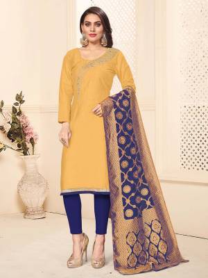 For Your Semi-Casual Wear, Grab This Designer Embroidered Dress Material In Yellow Colored Top Paired With Contrasting Navy Blue Colored Bottom And Dupatta. This Dress Material Is Cotton Based Paired With Banarasi Silk Fabricated Dupatta. 
