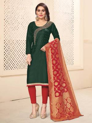 For Your Semi-Casual Wear, Grab This Designer Embroidered Dress Material In Pine Green Colored Top Paired With Contrasting Red Colored Bottom And Dupatta. This Dress Material Is Cotton Based Paired With Banarasi Silk Fabricated Dupatta. 