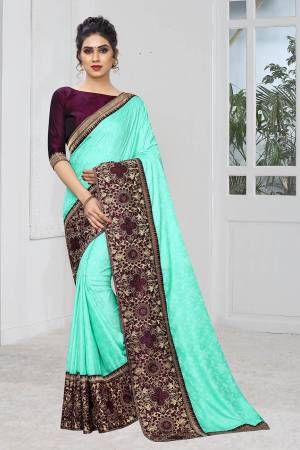 Celebrate This Festive Season With This Designer Elegant Saree In Sea Green Color Paired With Contrasting Wine Colored Blouse. This Saree Is Fabricated On Jacquard Silk Paired With Art Silk Fabricated Blouse. Its Broad Border Is Beautified With Heavy Jari & Stone Work. 