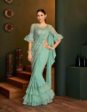 A modernistic approach to party-wear sarees, this sea-green saree will take your fashion game a notch higher with its balanced addition of elements. 