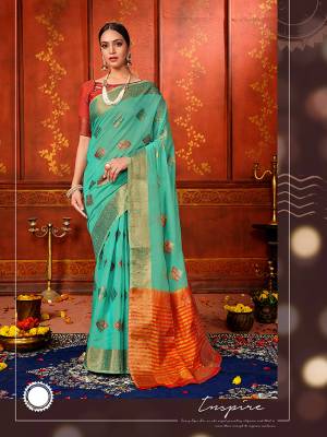 Celebrate This Festive Season With Beauty And Comfort Wearing This Pretty Silk Based Saree In Sea Green Color Paired With Contrasting Orange Colored Blouse. This Saree And Blouse Are Fabricated On Art Silk Beautified With Weave.