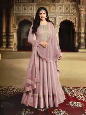 Get Ready For The Upcoming Wedding And Festive Season With This Heavy Designer Floor Length Suit In Dusty Pink Color. Its Embroidered Top Is Fabricated On Georgette Paired With Santoon Bottom And Net Fabricated Embroidered Dupatta. 