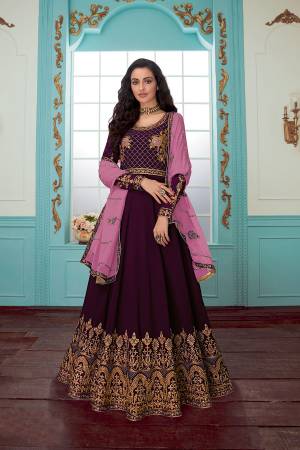 Get Ready For The Upcoming Wedding Season With This Designer Floor Length Suit In Wine Color Paired With Pink Colored Dupatta. Its Embroidered Top And Dupatta Are Georgette Based Paired With Santoon Fabricated Bottom. Buy Now.