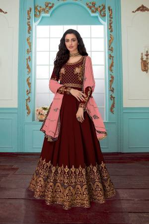 Get Ready For The Upcoming Wedding Season With This Designer Floor Length Suit In Maroon Color Paired With Peach Colored Dupatta. Its Embroidered Top And Dupatta Are Georgette Based Paired With Santoon Fabricated Bottom. Buy Now.
