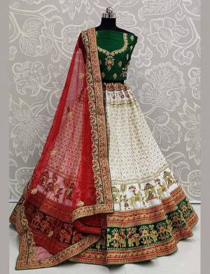 Here Is A Heavy Designer Lehenga Choli In A Proper Traditional Look With Traditional Color Combination In Dark Green Colored Blouse Paired With Rich White Colored Heavy Embroidered Lehenga And Contrasting Red Colored Dupatta. This Pretty Blouse And Lehenga Are Satin Based Paired With Net Fabricated Dupatta. 