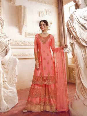 Add This Lovely Suit To Your Wardrobe In All Over Dark Peach Color. This Pretty Heavy Embroidered Suit Is Net Based Beautified With Attractive Embroidery. 