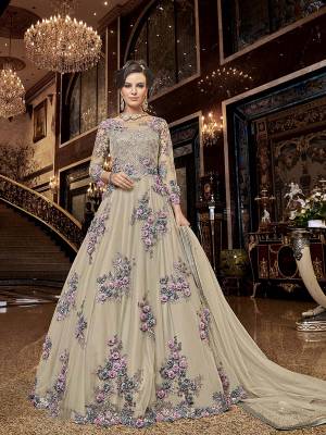 Flaunt Your Rich And Elegant Taste Wearing This Heavy Designer Floor Length Suit In Cream Color. Its Floor Length Top IS Net Based Beautified With Attractive Contrasting Embroidery Paired With Santoon Bottom And Net Fabricated Dupatta. 