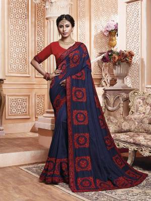Get Ready For The Upcoming Wedding And Festive Season With This Designer Saree In Navy Blue Color Paired With Contrasting Red Colored Blouse. This Contrasting Embroidered Saree Is Fabricated On Vichitra Silk Paired With Art Silk Fabricated Blouse.