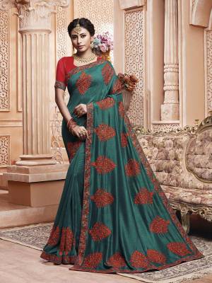 Get Ready For The Upcoming Wedding And Festive Season With This Designer Saree In Teal Blue Color Paired With Contrasting Red Colored Blouse. This Contrasting Embroidered Saree Is Fabricated On Vichitra Silk Paired With Art Silk Fabricated Blouse.
