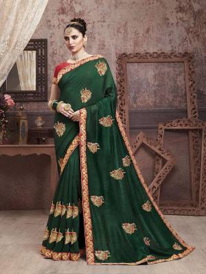 Add This Very Beautiful And Attractive Looking Designer Saree In Dark Green Color Paired With Contrasting Red Colored Blouse. This Saree Is Fabricated On Soft Art Silk Paired With Art Silk Fabricated Blouse. It Is Beautified With Embroidered Motifs Giving An Elegant Look To The Saree. 