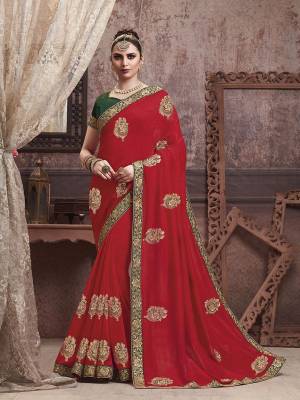 Celebrate This Festive Season With Beauty And Comfort In This Motif Embroidered Yet Elegant Saree In Red Color Paired With Contrasting Dark Green Colored Blouse. This Saree And Blouse are Silk Based Which Gives A Rich Look To Your Personality. 