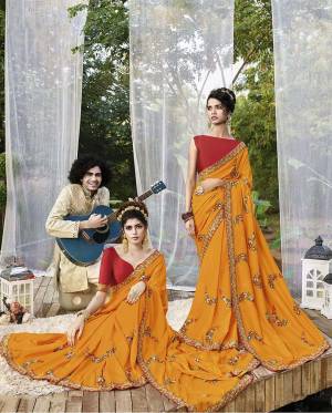 Here Is A Rich Silk Based Designer Saree In Musturd Yellow Color Paired With Red Colored Blouse. This Pretty Saree Is Beautified With Detailed Embroidery Giving An Attractive Look. 