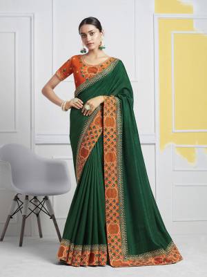Add This Pretty Designer Saree In Dark Green Color Paired With Contrasting Rust Orange Colored Blouse. This Saree Is Fabricated On Soft Art Silk Paired With Art Silk Fabricated Blouse. Buy This Saree Now. 