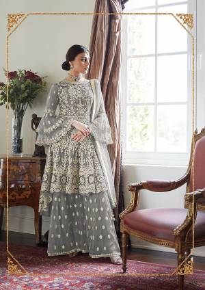 Here Is A Very Pretty And Heavy Designer Sharara Suit In All Over Grey Color. Its Pretty Embroidered Top, Bottom And Dupatta Are Fabricated On Net. It Is Light In Weight And Easy To Carry Throughout The Gala. 