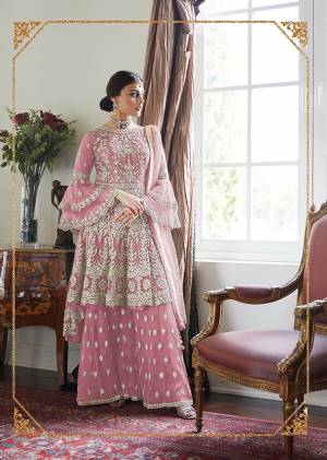 Here Is A Very Pretty And Heavy Designer Sharara Suit In All Over Pink Color. Its Pretty Embroidered Top, Bottom And Dupatta Are Fabricated On Net. It Is Light In Weight And Easy To Carry Throughout The Gala. 