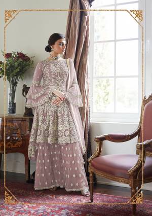Here Is A Very Pretty And Heavy Designer Sharara Suit In All Over Mauve Color. Its Pretty Embroidered Top, Bottom And Dupatta Are Fabricated On Net. It Is Light In Weight And Easy To Carry Throughout The Gala. 