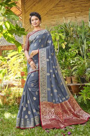 You Will Definitely Earn Lots Of Compliments Wearing This Designer Silk Based Saree In Grey Color Paired With Maroon Colored Blouse. It Is Beautified With Weave Giving An Attractive Look. 