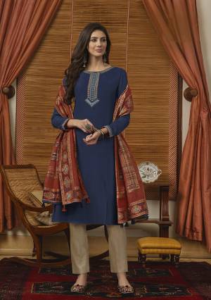 Get Ready For The Upcoming Festive Season With This Pretty Colorful Straight Suit In Blue Colored Top Paired With Contrasting Beige colored Bottom And Rust Orange Colored Dupatta. Its Top Is Muslin Based Paired With Cotton Bottom And Silk Handloom Dupatta. 