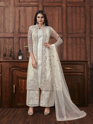 Here Is A Beautiful Heavy Embroidered Designer Suit In White Color Which Also Comes With A Heavy Embroidered Jacket, This Pretty Suit Is Net Based With Satin Inner. Buy This Semi-Stitched Suit Now.