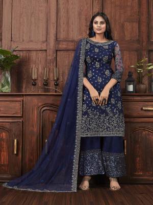 Here Is A Beautiful Heavy Embroidered Designer Suit In Navy Blue Color Which Also Comes With A Heavy Embroidered Jacket, This Pretty Suit Is Net Based With Satin Inner. Buy This Semi-Stitched Suit Now.