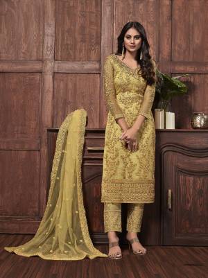 Get Ready For The Upcoming Festive And Wedding Season With This Designer Straight Suit In Yellow Color Fabricated On Net. It Is Beautified With Heavy Embroidery Over Top, Bottom and Dupatta. 