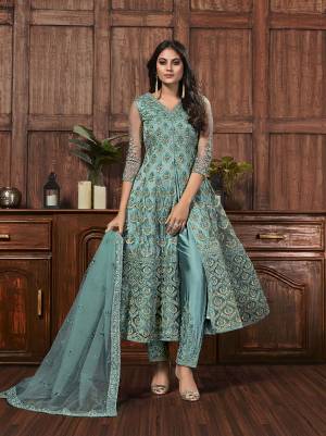 Get Ready For The Upcoming Festive And Wedding Season With This Designer Straight Suit In Turquoise Blue Color Fabricated On Net. It Is Beautified With Heavy Embroidery Over Top, Bottom and Dupatta. 