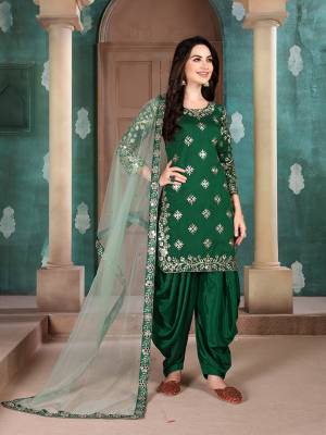 Here Is An Attractive Looking Mirror Embroidered Heavy Designer Suit In Dark Green Color Paired With Light Green colored Dupatta. Its Top Is Fabricated On Art Silk Paired With Santoon Bottom And Net Fabricated Dupatta. Also, Its Dupatta Is Beautified With Embroidered Lace Border. 