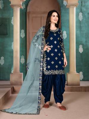Here Is An Attractive Looking Mirror Embroidered Heavy Designer Suit In Royal Blue Color Paired With Grey colored Dupatta. Its Top Is Fabricated On Art Silk Paired With Santoon Bottom And Net Fabricated Dupatta. Also, Its Dupatta Is Beautified With Embroidered Lace Border. 
