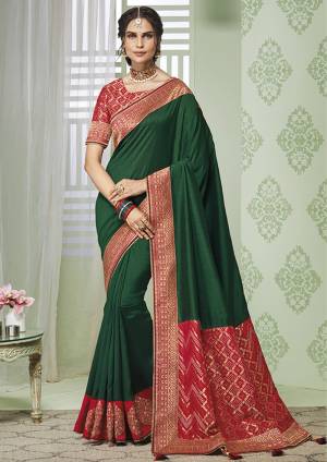 Celebrate This Festive Season With beauty And Comfort Wearing This Designer Saree In Dark Green Color Paired With Contrasting Red Colored Blouse. This Saree And Blouse Are Silk Based Beautified With Minimal Embroidery. 