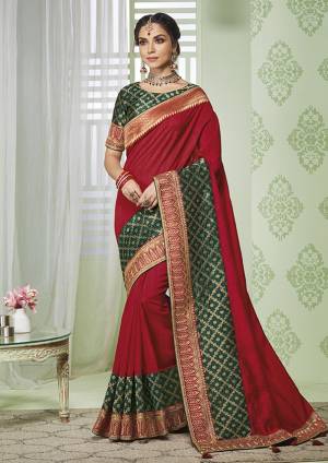 Enhance Your Personality Wearing This Rich Silk Based Designer Saree In Red color Paired With Contrasting Dark Green Colored Blouse. It Is Beautified With Pretty Embroidery Over The Lace Border. 