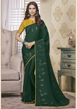 Adorn The Pretty Angelic Look Wearing This Designer Elegant Looking Saree In Dark Green Color. This Pretty Saree And Blouse Are Fabricated On Soft Satin Beautified With Pretty Stone Work. Its Lovely Color And Stone Work Will Definitely Earn You Lots Of Compliments From Onlookers. 