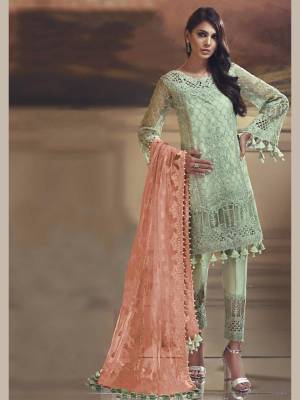 Grab This Pretty Straight Suit In Pastel Green Color Paired With Contrasting Peach Dupatta. Its Top Is Fabricated On Tissue Silk Paired With Santoon Bottom And Net Fabricated Dupatta. Buy This Suit Now.