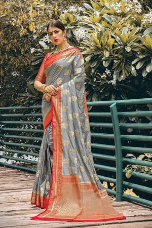 Adorn A Proper Traditional Look In This Designer Weaved Saree In Grey Color Paired With Red Colored Blouse. This Saree And Blouse Are Nylon Silk Based Beautified With Weave. 