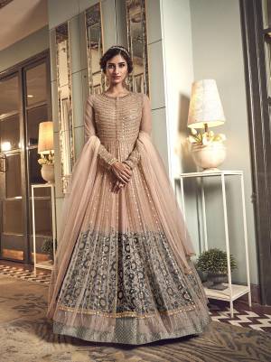 For An Elegant Look, Grab This Heavy Designer Indo-Western Suit In Peach And Grey Color. Its Has Beautiful Embroidered Net Based Gown With Net Jacket, Paired With Soft silk Fabricated Bottom And Net Dupatta, Also It Has Very Pretty Peach And Grey Colored Shaded Inner Fabricated On Satin Georgette. 