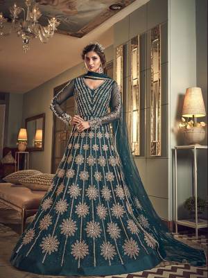Add This New Shade To Your Wardrobe With This Heavy Designer Floor Length Suit In Teal Blue Color. Its Heavy Embroidered Top Is Fabricated On Net Paired With Soft Silk Bottom And Net Dupatta. 