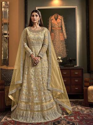 Pretty Simple And Elegant Heavy Designer Suit Is Here In Light Yellow Color. Its Top And Dupatta Are Net Based Paired Wth Soft Silk Fabricated Bottom, Buy Now.
