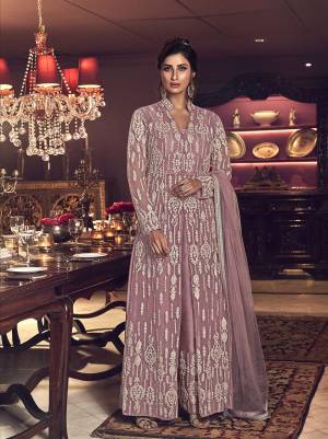 Look Pretty In This Designer Indo Western Suit In Pastel Pink Color. Its Heavy Embroidered Top IS Fabricated On Net Paired with Art Silk Fabricated Embroidered Pants And Net Dupatta. 