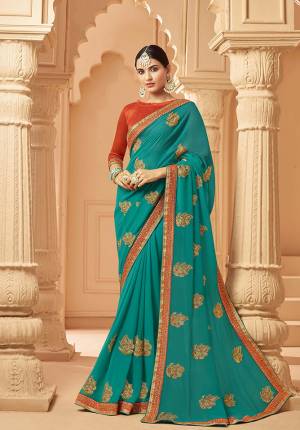 Catch All The Limelight At The Next Function You Attend In This Very Pretty Designer saree In Blue Color Paired With Contrasting Orange Colored Blouse. It Is Beautified With Embroidered Motifs Giving An Elegant Look. Buy  This Saree Now.