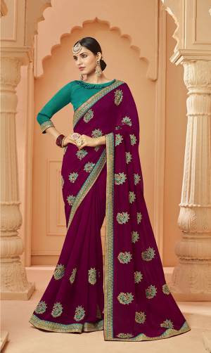Add This Very Pretty And Elegant Looking Designer Saree In Wine Color Paired With Contrasting Blue Colored Blouse. This Saree Is Fabricated On Georgette Beautified With Pretty Embroidered Motifs Paired With Art Silk Fabricated Blouse. 